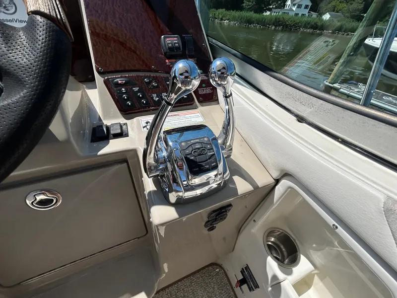 Slide: The Image of 2008 Sea Ray 330 Sundancer helm with dual throttle controls and steering wheel. - 12