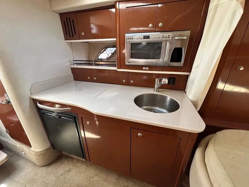 Slide: The Image of 2008 Sea Ray 330 Sundancer yacht kitchen with sink, microwave, and compact fridge. - 25