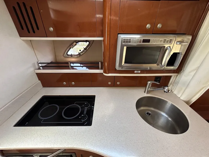 Slide: The Image of 2008 Sea Ray 330 Sundancer kitchen with stove, microwave, and sink. - 26