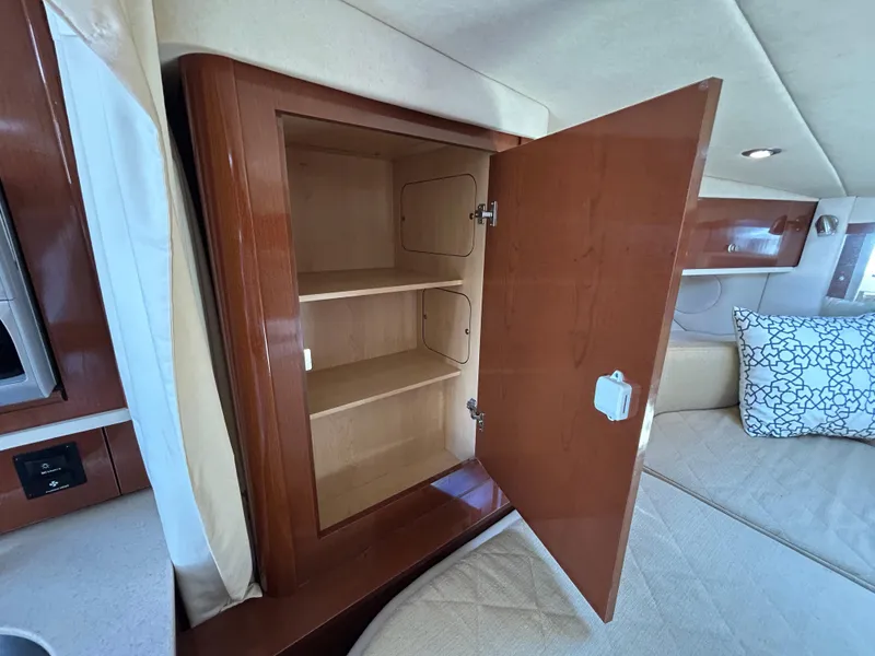 Slide: The Image of 2008 Sea Ray 330 Sundancer interior cabinet with open wooden door and shelves. - 27