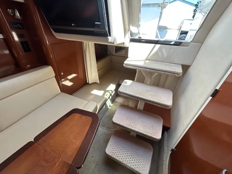 Slide: The Image of Interior of 2008 Sea Ray 330 Sundancer with stairs, seating, and wooden table. - 29