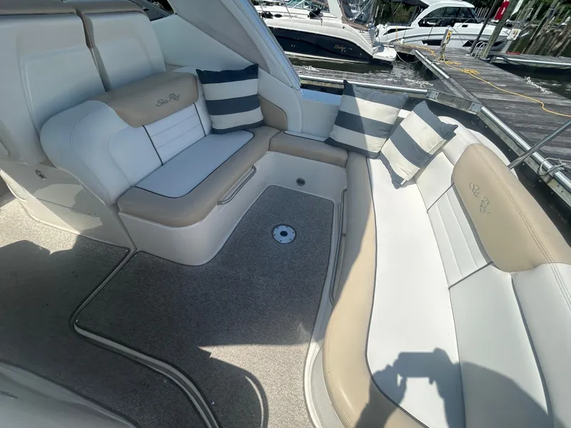 Slide: The Image of 2008 Sea Ray 330 Sundancer boat interior with cushioned seating and striped pillows. - 6