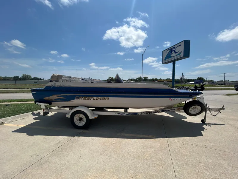 Slide: The Image of 1999 Crestliner Rampage 2000 boat on trailer, parked outdoors under a clear blue sky. - 3