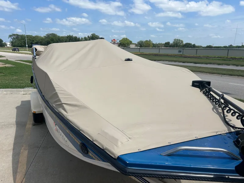Slide: The Image of 1999 Crestliner Rampage 2000 boat with beige cover, parked outdoors on a sunny day. - 4