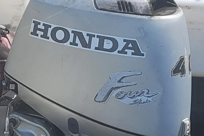 Slide: The Image of Honda Four Stroke outboard motor, silver, with visible branding and model details. - 6