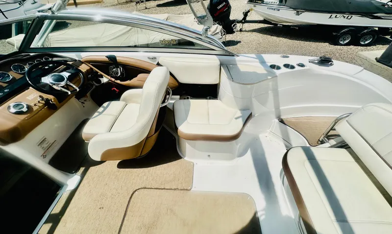 Slide: The Image of Interior of 2012 Cobalt 243 boat with beige and white seating, steering wheel, and dashboard. - 10