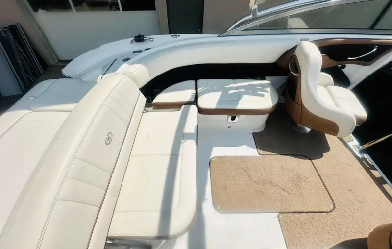 Slide: The Image of Interior of 2012 Cobalt 243 boat with white and brown seating, carpeted floor. - 11