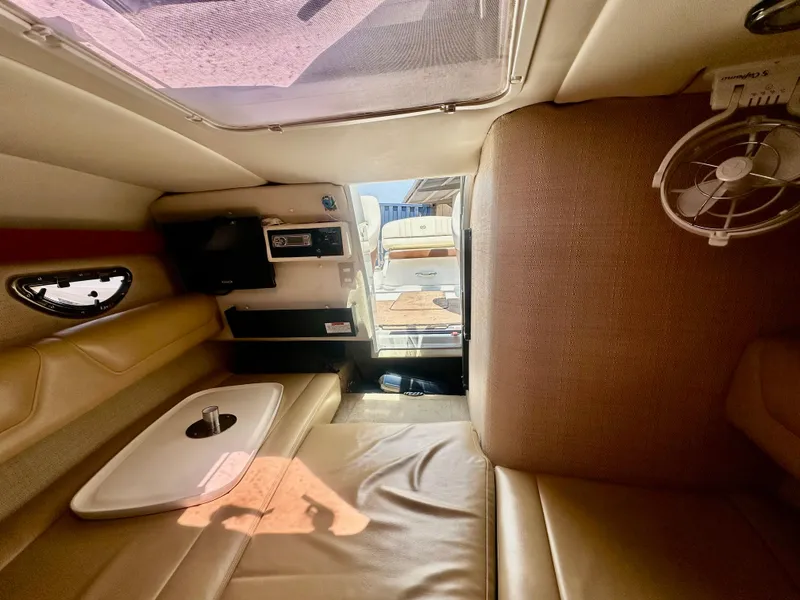 Slide: The Image of Interior of 2012 Cobalt 243 boat with beige seating and compact cabin amenities. - 15