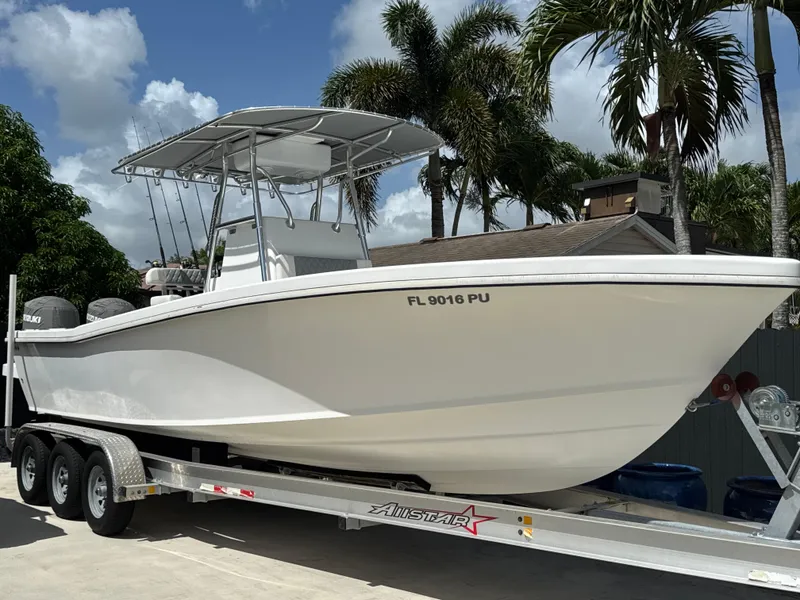 Slide: The Image of 2015 Ocean Master 296 boat on trailer, surrounded by palm trees and blue sky. - 0