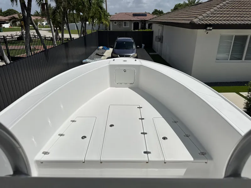 Slide: The Image of 2015 Ocean Master 296 boat in driveway, surrounded by palm trees and houses. - 11