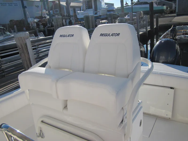 Slide: The Image of 2015 Regulator 25FS Center Console boat with dual white seats at the helm. - 13