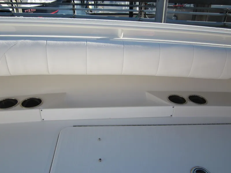 Slide: The Image of 2015 Regulator 25FS Center Console boat interior with white cushioned seating and cup holders. - 21