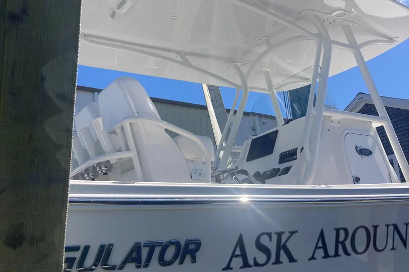 Slide: The Image of 2015 Regulator 25FS Center Console boat with white seating and control panel. - 24