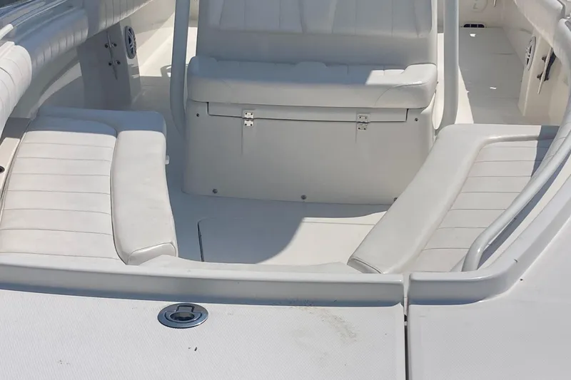 Slide: The Image of 2015 Regulator 25FS Center Console boat interior with white seating and storage. - 29