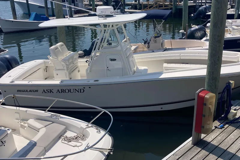 Slide: The Image of 2015 Regulator 25FS Center Console boat docked at a marina. - 33