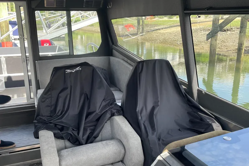 Slide: The Image of Interior of 2024 Viggo C10 boat with covered seats and waterfront view. - 13