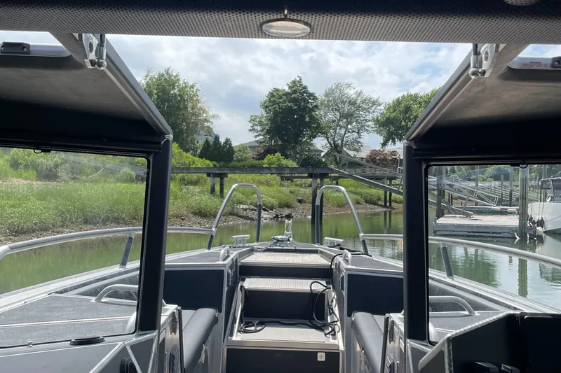 Slide: The Image of 2024 Viggo C10 boat interior with open canopy, docked near lush greenery. - 16