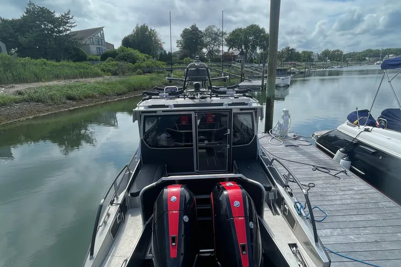 Slide: The Image of 2024 Viggo C10 boat docked by a serene riverside with lush greenery. - 2