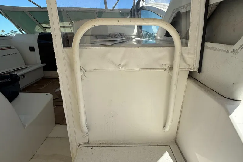 Slide: The Image of 1998 Hatteras 39 Sport Express interior with white seating and protective railing. - 11