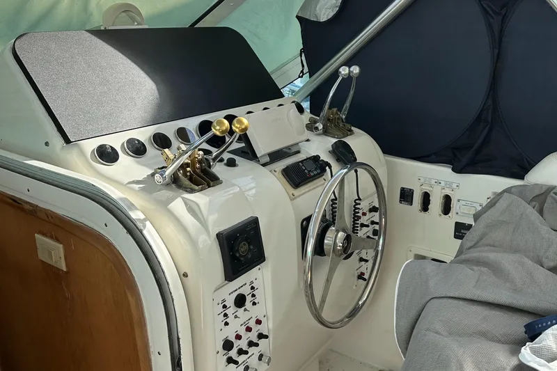 Slide: The Image of Control panel of a 1998 Hatteras 39 Sport Express boat with steering wheel and throttle levers. - 2