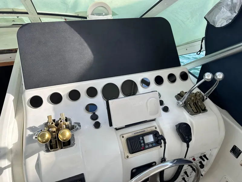 Slide: The Image of Control panel of a 1998 Hatteras 39 Sport Express boat with steering wheel and gauges. - 3