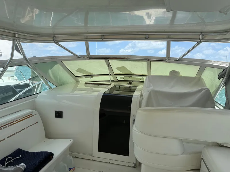 Slide: The Image of 1998 Hatteras 39 Sport Express yacht interior with white seating and clear windows. - 4