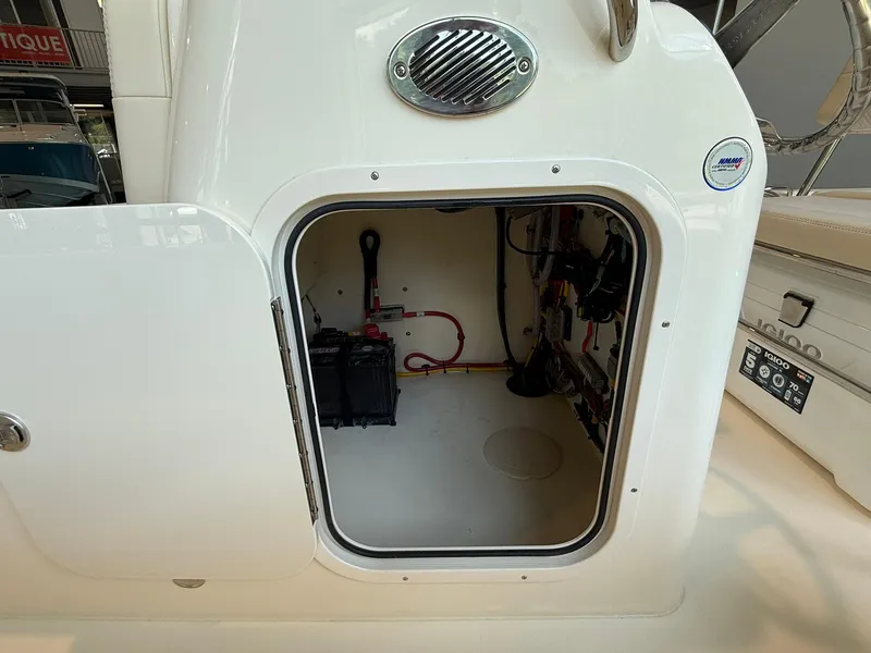 Slide: The Image of 2026 Scout 188 SF boat storage compartment with battery and wiring visible. - 11