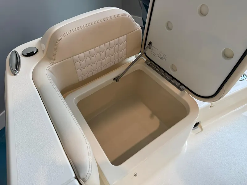 Slide: The Image of 2026 Scout 188 SF boat storage compartment with open lid, featuring cushioned seating. - 18