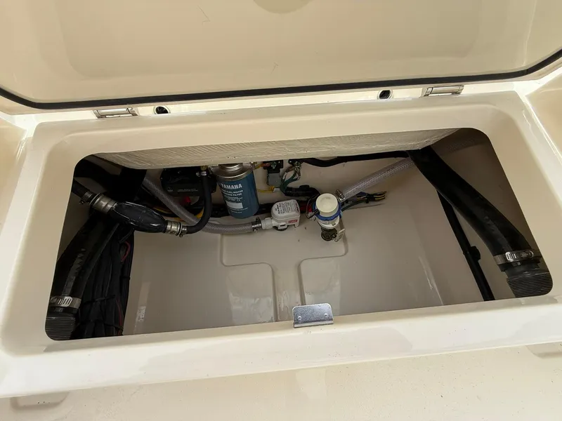 Slide: The Image of Open compartment of 2026 Scout 188 SF boat showing internal components and wiring. - 19