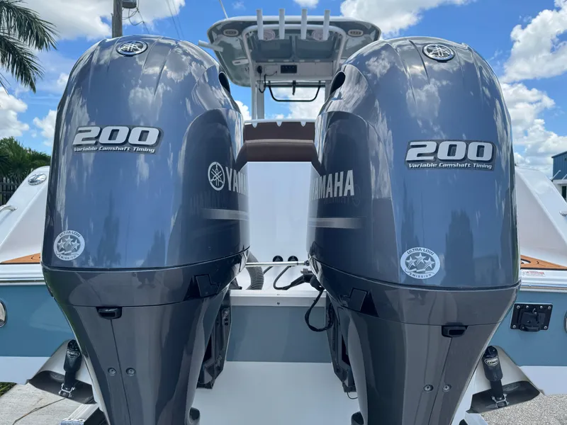 Slide: The Image of 2019 Sea Hunt Ultra 275 SE with twin Yamaha 200 engines, clear sky background. - 12