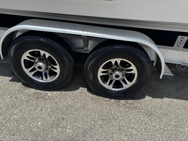 Slide: The Image of Trailer wheels of a 2019 Sea Hunt Ultra 275 SE boat on pavement. - 25
