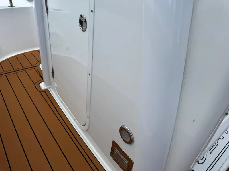 Slide: The Image of 2019 Sea Hunt Ultra 275 SE boat interior with teak-style flooring and white paneling. - 41