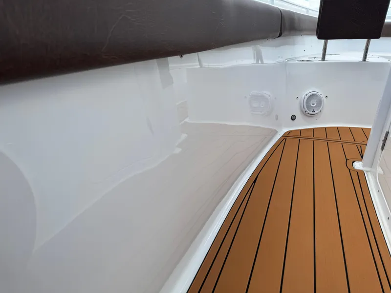 Slide: The Image of 2019 Sea Hunt Ultra 275 SE boat interior with teak-style flooring and cushioned seating. - 42