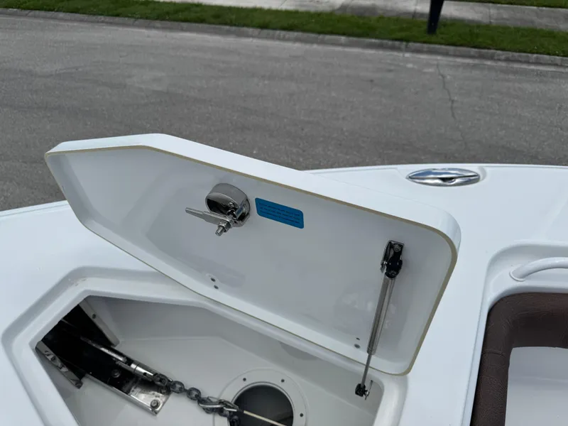 Slide: The Image of Open anchor compartment on 2019 Sea Hunt Ultra 275 SE boat, showing chain and latch mechanism. - 44