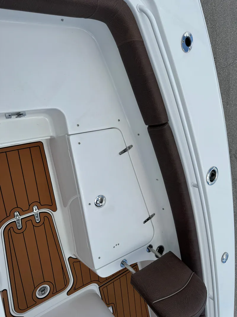 Slide: The Image of 2019 Sea Hunt Ultra 275 SE boat interior with brown cushioned seating and wood-patterned flooring. - 46