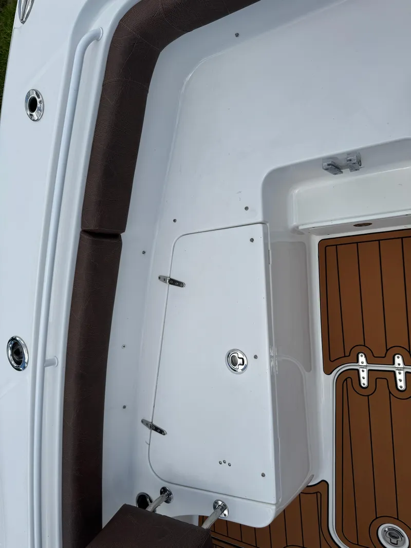 Slide: The Image of 2019 Sea Hunt Ultra 275 SE boat interior with brown cushioned seating and wood-patterned flooring. - 47