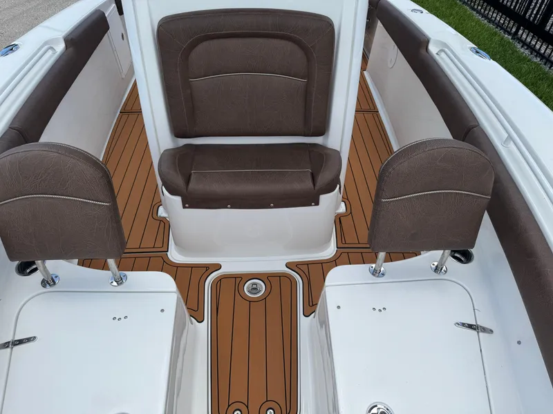 Slide: The Image of 2019 Sea Hunt Ultra 275 SE boat interior with brown seating and wood-style flooring. - 48