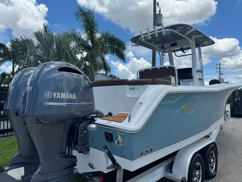 Slide: The Image of 2019 Sea Hunt Ultra 275 SE boat with dual Yamaha engines, parked near palm trees. - 5
