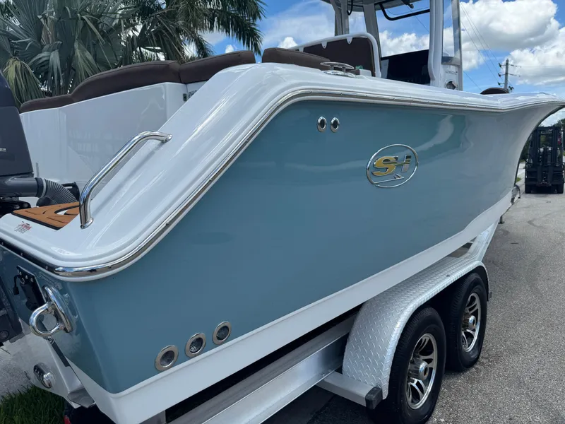 Slide: The Image of 2019 Sea Hunt Ultra 275 SE boat on trailer, blue hull, palm trees in background. - 6