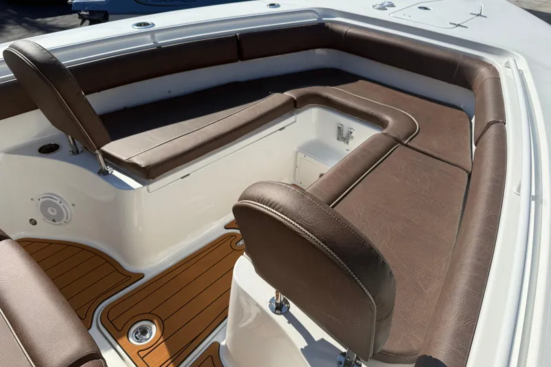Slide: The Image of 2019 Sea Hunt Ultra 275 SE boat interior with brown cushioned seating and teak flooring. - 68