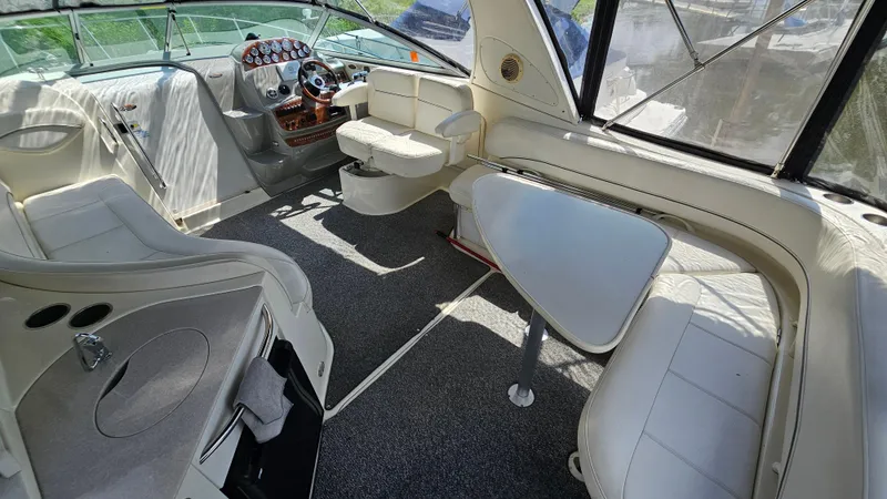 Slide: The Image of 2009 Bayliner 340 SB boat interior with seating, table, and helm controls. - 11