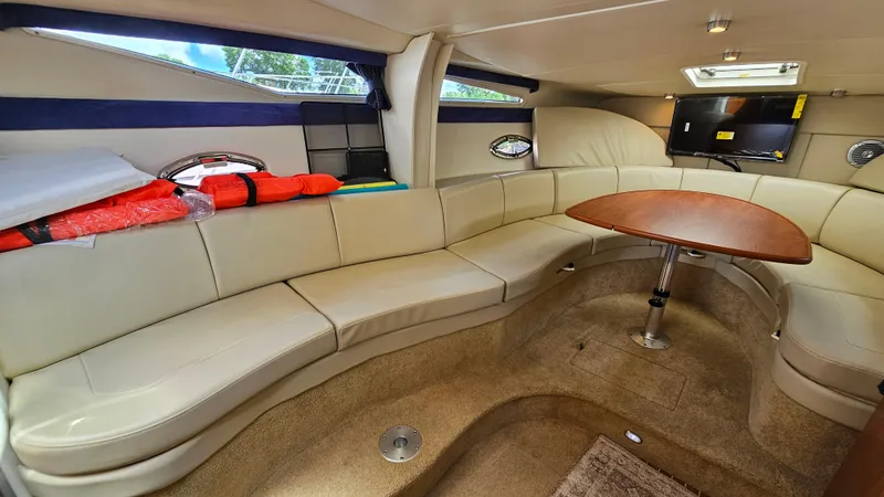 Slide: The Image of Interior of 2009 Bayliner 340 SB yacht with beige seating and wooden table. - 17