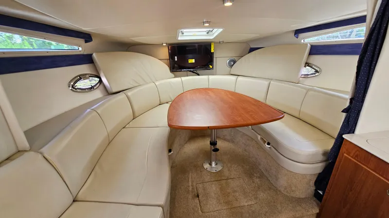 Slide: The Image of 2009 Bayliner 340 SB cabin interior with beige seating and wooden table. - 18