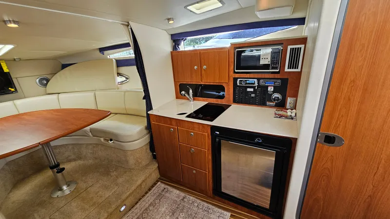 Slide: The Image of Interior of 2009 Bayliner 340 SB yacht with kitchenette and seating area. - 19