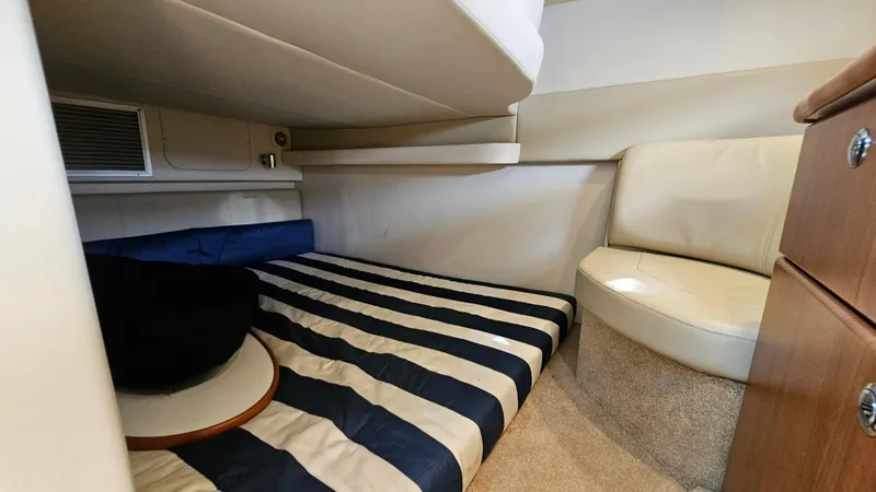 Slide: The Image of 2009 Bayliner 340 SB cabin interior with striped bedding and seating area. - 25