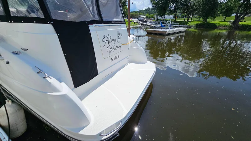 Slide: The Image of 2009 Bayliner 340 SB docked on a calm lake with lush greenery. - 3