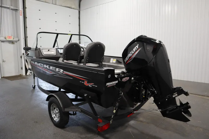 Slide: The Image of 2023 Tracker V16 Pro Guide WT boat with Mercury engine in a garage setting. - 47