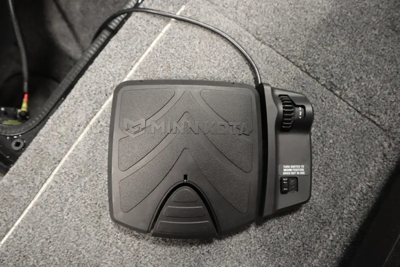 Slide: The Image of Minn Kota foot pedal on 2023 Tracker V16 Pro Guide WT boat carpet. - 7