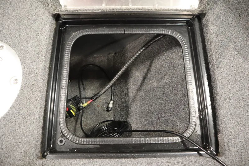 Slide: The Image of 2023 Tracker V16 Pro Guide WT storage compartment with wiring and carpeted interior. - 9