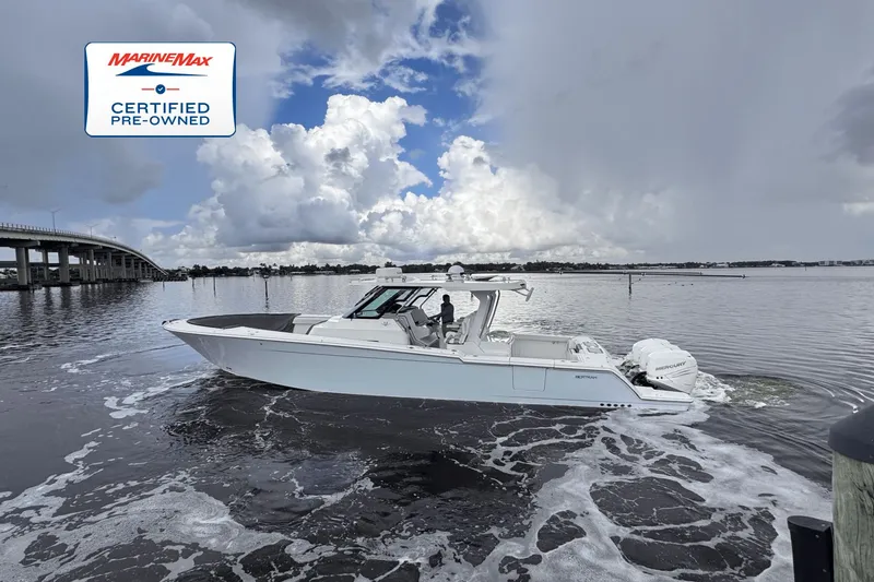 Slide: The Image of A white boat cruising on calm water, with a bridge in the background. - 0